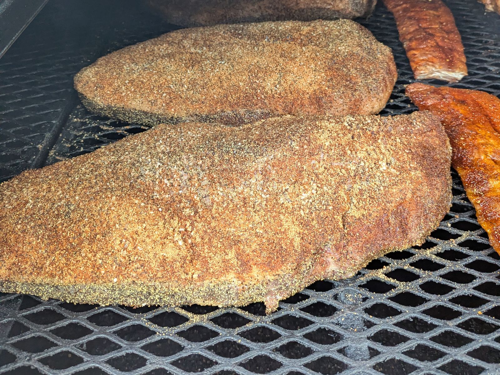 Texas-style briskets and spare ribs starting their cook on the grate