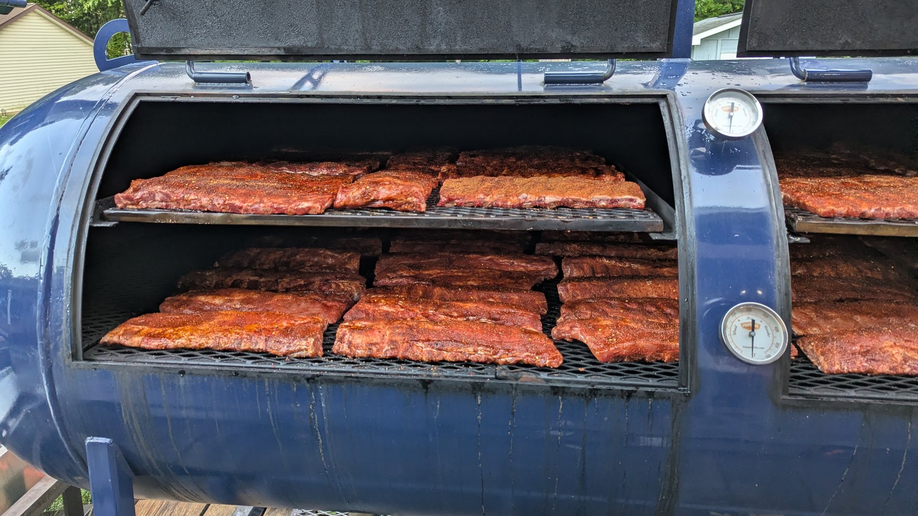 Offset smoker loaded with racks of ribs for a catering cook
