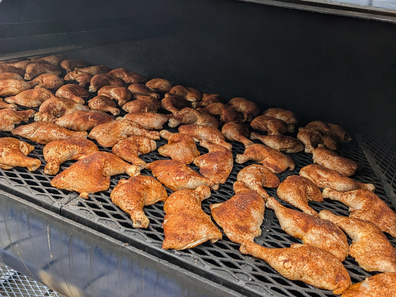 Chicken quarters covering the grate of the Primitive Pits offset for a catering cook