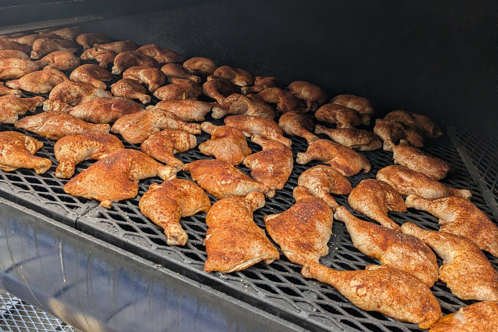 Chicken quarters covering the grate of the Primitive Pits 500-gallon offset